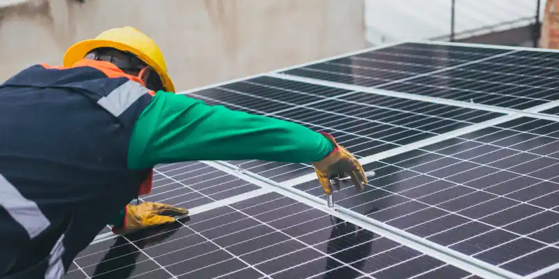 A specialist mounting solar panels on a rooftop.